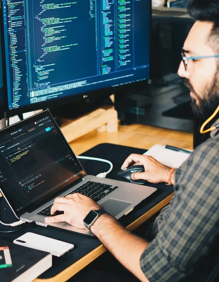 Someone working at a dual-monitor desk